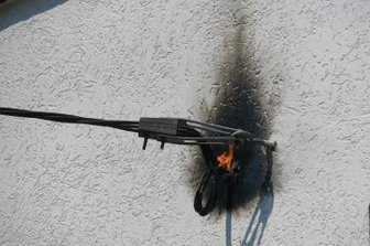 Stromkabel an Haus gerät in Brand - Die brennende Elektroleitung an der Hauswand.