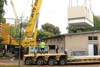 Stromversorgung der Tram in Zwickau: SVZ investieren Millionen an Linie 4 - Ein Gleichrichterunterwerk am Haken eines Krans am Georgenplatz.