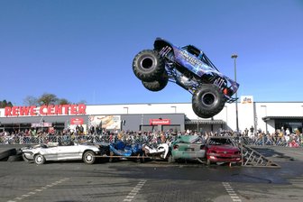 Stuntshow auf Obi-Parkplatz in Meerane: Wirkt sich ein Unfall in Baden-Württemberg auf das Sicherheitskonzept aus? - Hier segelt der Monstertruck „Thunderstruck“ über ein halbes Dutzend Altfahrzeuge.