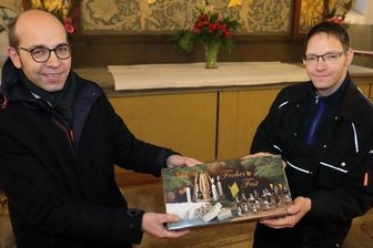 Süßes Dankeschön für die "gute Seele" von St. Georgen - Pfarrer Christian Schubert (l.) überreichte Kirchner Jörg Windisch einen Dankeschönstollen aus der Bäckerei Müller in Breitenbrunn.