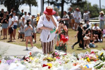 Sydney warnt vor weiterem Unheil - Mahnwache: Eine Frau trauert am Ort es Massakers.