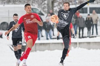 Syrau zieht fast doppelt ins Viertelfinale - Angelo Tarnawski (in Rot) von Fortuna Plauen im Zweikampf mit dem Syrauer Tobias John. Auf dem schneebedeckten Kunstrasenplatz des Vogtlandstadions setzte sich Syrau nach 0:1-Rückstand noch 3:1 durch.