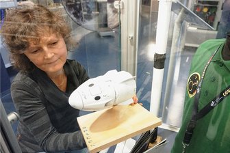 T-Shirt von deutschem Top-Astronaut jetzt in vogtländischer Raumfahrtschau zu sehen - Museumsleiterin Romy Mothes räumt ein Modell in die Vitrine ein, die dem deutschen Astronauten Matthias Maurer gewidmet ist.
