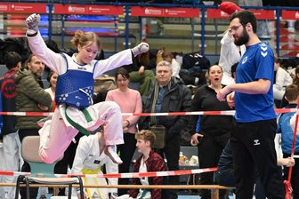 Taekwondo-Turnier im Erzgebirge weckt böse Erinnerung: „Da fiel meine Tochter einfach um“ - Freudensprung: Frieda Goral von der SG Nickelhütte Aue holte unter den Augen ihres Trainers Justin Unger (r.) beim 26. Nickelhütten-Turnier Bronze.
