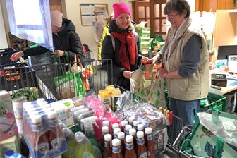 Tafel in Freiberg ist am Anschlag: Ausgabe für Bedürftige benötigt selbst Hilfe - Helferin Petra (v. r.) packt Tetiana bei der Freiberger Tafel Lebensmittel in den Beutel. Die Einrichtung an der Friedeburger Straße gehört zum Caritasverband für Chemnitz und Umgebung. Nach Angaben des Vereins werden hier und in den Ausgabestellen in Flöha und Eppendorf 4200 Menschen versorgt. Ein Drittel davon seien Kinder.