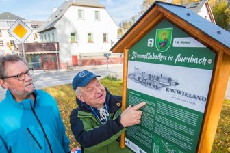 Tafeln erinnern an 100-jährige Tradition - Der stellvertretende Bürgermeister Dieter Herold (links) und Christian Sehm, Vorsitzender des Heimatvereins Auerbach, die an einer der Geschichtstafeln an insgesamt sieben ehemaligen Strumpffabriken im erzgebirgischen Auerbach stehen. 