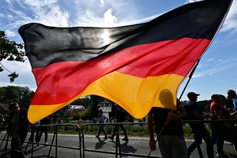 Tag der Deutschen Einheit in Mödlareuth: Wie die Polizei den „Sicherungseinsatz“ bewertet - Eine Deutschlandfahne wird auf dem Weg zu einer Wahlkampf-Veranstaltung der AfD unweit vom Deutsch-Deutschen Museum Mödlareuth geschwenkt.