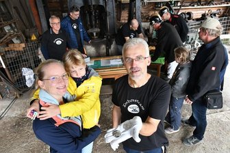 Tag des offenen Denkmals in Großschirma: Hier wird die Medaille mit dem Freiberger Tivoli geprägt - Tim Meyer (vorne) zeigt beide Seiten der Medaille. Lysann Christoph mit Jasmin (7) aus Halsbrücke schauen sie sich an.