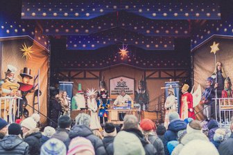 Tag des weihnachtlichen Handwerks: Erzgebirger bei Premiere auf Striezelmarkt dabei - Beobachtet von den Striezelmarktfiguren, drechselt Martin Steinert aus Olbernhau auf der großen Bühne den Körper eines Räuchermännchens.