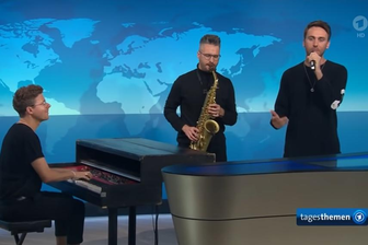 "Tagesthemen": Clueso tritt mit Musikern aus Plauen und Zwickau auf - Sascha Stiehler, Antonio Lucaciu und Sänger Clueso (von links) spielten am Freitagabend im "Tagesthemen"-Studio an der Seite von Caren Miosga.