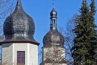 Taltitz an der Pirk ist ein Dorf mit zwei Türmen - Die Taltitzer Dorfkirche im Hintergrund neben dem Eckturm des früheren Rittergutes.