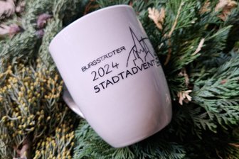 Tasse statt Pappbecher: Wie Burgstädt seine eigene Tasse für den Stadtadvent bekommt - So sieht die neue Glühweintasse für den Burgstädter Weihnachtsmarkt aus. Zum Stadtadvent am 14. und 15. Dezember werden 30 Stück zum Preis von 9 Euro angeboten. Raumausstatterin Yvonne Mehner vom Gewerbeverein hat sie nett in Szene gesetzt.