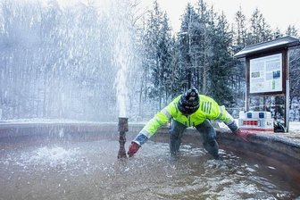 Taugt der Wärmespeicher unter dem Geysir von Geilsdorf als Heizer für ganz Plauen? - Erschwerte Bedingungen bei klirrenden Minustemperaturen: Horst Kämpf füllt eine Gasmaus mit dem Gas aus der warmen Quelle in Neumühle bei Geilsdorf. Das vorher eingesogene Wasser wird dabei verdrängt.