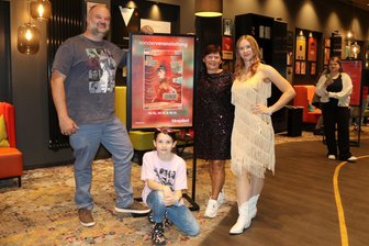 Taylor-Swift-Releaseparty zu „Life as a Showgirl“ im Zwickauer Kino: Glitzerlook, Tattoos und Freundschaftsbänder - Freitagabend im „Astoria“: Nancy Matthias (r.) mit Mutter Heike und Lars Döhler mit Tochter Melinda flankieren das Plakat zur Release Party des neuen Albums von Taylor Swift.