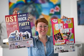 Techno, Ostrock und Schlager: Diese Bands kommen nach Burgstädt - Sarah Köllner vom Burgstädter Kulturverein zeigt Plakate für die Feten im August. Sie ist für die Organisation verantwortlich.