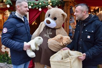 Teddys statt Autozubehör: Warum zwei Chemnitzer auf dem Weihnachtsmarkt auf Plüsch setzen - Aron Pöschl (links) erhält Teddys für den guten Zweck von Andy Lang.