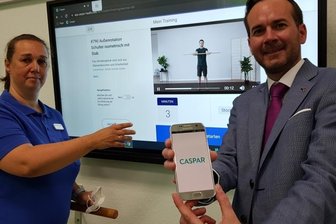 Tele-Nachsorge neu in Klinik Brambach - Klinikleiter Tim Schmachtenberg und Therapieleiterin Marén Schiller zeigen den digitalen Nachsorge-Therapeuten mit Namen Caspar. Die Einweisungerfolgt während des Klinikaufenthaltes, später zu Hause können die Patienten ihre Übungen in Eigenregie absolvieren - sie ersparen sich damit Wege und sind zeitlich flexibel.