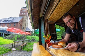 Terrasse und Imbiss machen Berghotel auf dem Bärenstein komplett - Bei der Neugestaltung des Außengeländes hat auch der bisher provisorische Imbiss ein neues Aussehen und einen neuen Standort bekommen. Für Radfahrer und Wanderer ist er an den Wochenenden jeweils von 10 bis 17 Uhr geöffnet. Chef Dennis Feist macht schon mal Appetit.