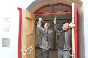 Theater Freiberg: Diese neue Tür öffnet und schließt mehr als 200 Mal am Tag - Mitarbeiter der Firma Hermsdorf bauen die neue Tür am Bühneneingang des Theaters an der Borngasse in Freiberg ein. Im Bild von links Matthias Haase (l.) und Mike Dulewicz.