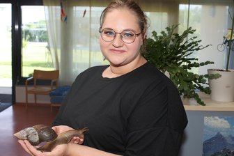 Therapie mit Riesenschnecken: Wie die schleimigen Weichtiere in einer Werdauer Einrichtung ankommen - Mitarbeiterin Ribanna Sieb, die aktuell ihr freies soziales Jahr in der Diakonie absolviert, beobachtet den Umgang mit den Schnecken genau, sodass diese nach jeder Streicheleinheit wieder sicher im Terrarium landen.