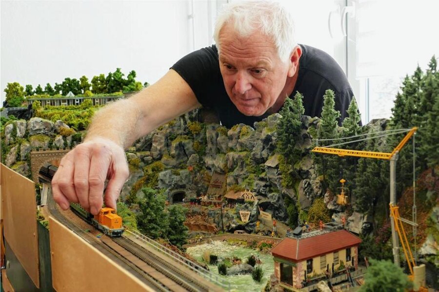 Thermalbad Wiesenbad in Mini: Herr Neumann baut das Erzgebirge nach - Auf seiner Modellbahnanlage in Krumhermersdorf setzt Wilfried Neumann probeweise einen Zug in die Gleise. 
