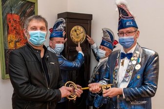 Thronfolge mit Wartezeit - Die Macht im Rochlitzer Rathaus haben die Narren übernommen. Oberbürgermeister Frank Dehne hat den Rathausschlüssel an Präsident Raymond Lange (re.) übergeben. Schatzmeister Ingo Matthes (hinten, li.) und Zeremonienmeister Dominik Grabner behielten die Uhr im Auge.