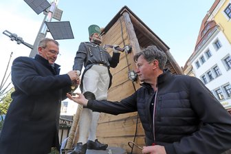 Tipps für den Advent in Freiberg: Was ist neu auf dem Christmarkt in der Silberstadt? - Freibergs Oberbürgermeister Sven Krüger (l.) und Holzbildhauermeister Jesko Lange legen letzte Hand an eine der neuen Holzfiguren für den Freiberger Christmarkt.