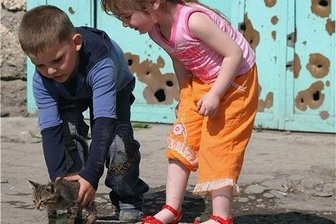 Tod, Taxis und Techno - Kinder spielen vor einem Tor mit Einschusslöchern aus dem Kaukasus-Konflikt: Georgien sucht derzeit Frieden in einer West-Anbindung, von der auch viele Romane des Landes auf der Buchmesse erzählen.