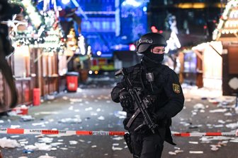 Todesfahrer von Magdeburg schreibt aus Gefängnis: „Bin bereit, weitere Deutsche zu schlachten“ - Nach der Bluttat am 20. Dezember 2024 steht eine schwer bewaffnete Polizistin in Magdeburg auf dem Weihnachtsmarktgelände.