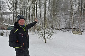 Tollkühne Ski-Springer im Erzgebirge: Im Auslauf ging es sogar über einen Bach und die Hauptstraße - Sportler André Helbig zeigt auf den Hang der ehemaligen Skischanze in Gahlenz.