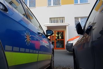 Toter Säugling in Plauener Wohnung gefunden - Einsatzkräfte am Eingang zum Wohnhaus an der Straße der Deutschen Einheit.