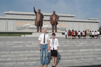Tour ins Land des Raketenmanns: Warum dieser vogtländische Feuerwehrmann nach Nordkorea gereist ist und was er dort erlebte - Stefan Marienthal steht neben seiner Reiseleiterin in Nordkorea. Im Hintergrund befinden sich die Statuen von Staatsgründer Kim Il Sung (links) und seinem Sohn und Nachfolger Kim Jong-il. Mittlerweile regiert dort Kim Jong Un.
