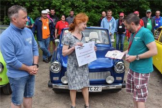Trabifahrer mit viel Herz machen in Oederan Station - Christina Riemer freut sich über eine Spende der Trabifans Sachsen. Ralf Lemnitzer (links) und Tino Schmidt von der Tour- und Vereinsleitung haben den Scheck und ein Starterschild übergeben.