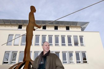 Trauer um Meeraner Künstler: Welche Spuren er in seiner Wahlheimat hinterlassen hat - Der Künstler Dieter Prange neben seiner Skulptur „Balance“ am Neuen Rathaus in Meerane.