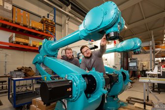 Trend zur E-Mobilität verhilft Plauener Firma zu Großauftrag - Ein Blick in die Elfin-Fertigungshalle an der Schöpsdrehe. Mitarbeiter Nico Schneider und Vertriebsleiter Rico Strobel (rechts) an einem Roboter für komplexe Handlungen.