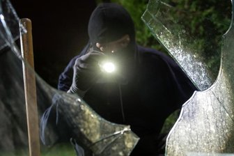 Trickbetrug und Einbruch: Polizei berät Bürger vor Ort - Ein Einbrecher (gestellte Szene) blickt durch eine eingeschlagene Fensterscheibe in ein Haus. Auch zum Thema Einbruchsschutz beraten Beamte der Polizeidirektion Zwickau demnächst auf ihrer Sommertour ratsuchende Bürger in der Region. 