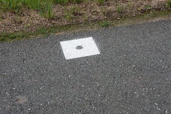 Triebel: Rätselhafte Markierungen beschäftigen Ämter - Weiße Quadrate mit einem Loch in der Mitte sind auf Straßen in den Gemeinden Triebel und Eichigt zu sehen.