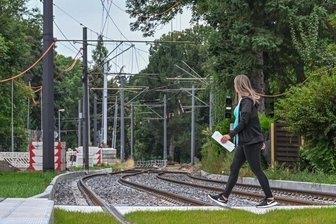 Trotz Klimakrise: Chemnitz baut neue Schottertrassen für Straßenbahnen - Blick auf die sanierte Strecke der Linie 5 im Chemnitzer Stadtteil Gablenz: Der Haltestellenbereich im Vordergrund ist mit Rasengleis versehen worden, die weiterführende Trasse dahinter in herkömmlicher Weise mit offenem Schotterbett. Ein Problem: Schotter heizt sich im Sommer stark auf und trägt so zur Hitze in der Stadt bei.