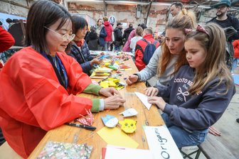 Trotz Regens: Spielfest in Chemnitz erlebt Besucheransturm - Keiko Okamura zeigt Melanie Pelzer und Tochter Maja (8) die Kunst des Origami-Papierfaltens.