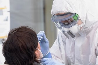 Trotz Testpflicht: Im ländlichen Raum fehlen Testzentren - Ein Mitarbeiter des Deutschen Roten Kreuzes macht in Schutzkleidung einen Abstrich. Seit Wegfall der Testpflichten sind die Angebote gerade auf dem Land weit weniger geworden. 