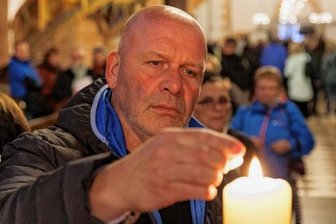 Trotziges Signal nach Berlin: Das Licht bleibt an im Erzgebirge - Unternehmer Torsten Köhler zündete nach der Friedensandacht in Sankt Annen eine Kerze an.