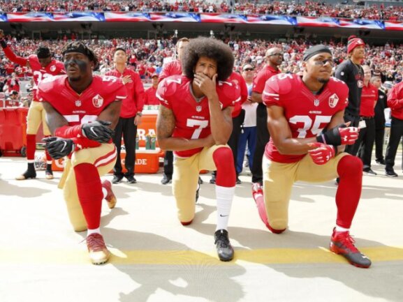 Trump nennt Knien bei der Hymne respektlos -  
          Colin Kaepernick (M.) kniete 2016 mit seinen Teamkollegen Eli Harold (l) und Eric Reid vor einem Spiel der San Francisco 49ers.