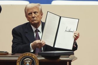 Trumps erster Tag im Amt: Der Polarsturm des neuen Präsidenten - US-Präsident Donald Trump hält eine Anordnung in die Höhe, nachdem er sie bei einer Veranstaltung mit Parade zu seiner Amtseinführung in der Capital One Arena unterzeichnet hat.