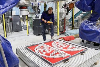 TU Chemnitz druckt weltweit ersten Beton-Schwibbogen - Enrico Rudolph vom Forschungsbereich "Leichtbau im Bauwesen" am Institut für Strukturleichtbau der Technischen Universität Chemnitz untersucht nach der Fertigung der Schwibbögen im Roboter-Komplex die Qualität des Schichtaufbaus des 3D-Betondrucks.
