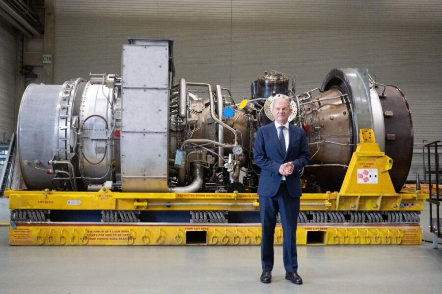 Bundeskanzler Olaf Scholz vor der in Kanada für die Erdgas-Pipeline Nordstream 1 gewarteten Turbine.