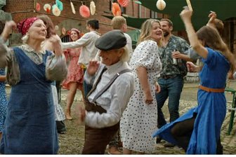 TV-Kritik für ZDF-Vogtland-Serie „Mandat für Mai“: Finale mit Wumms - Finale Szene: Babuschka (Marie Anne Fliegel, rotes Kopftuch) und die ganze Dorfgemeinschaft um Anwältin Mai (Julia Hartmann, rechts) tanzen.