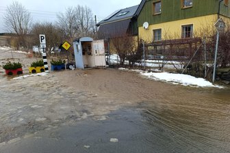 Überspülte Straßen im Erzgebirge: Tauwetter löst Feuerwehreinsätze aus - In Neudorf war die Straße „Am Steig“ betroffen, in unmittelbarer Nähe befinden sich Gleise der Fichtelbergbahn.