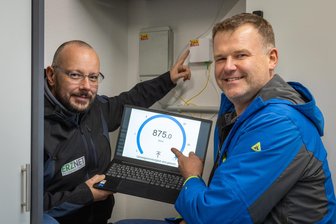 Ultra-schnelles Internet: Kommune im Erzgebirge erhält ersten Glasfaseranschluss - Wehrleiter Jörg Aurich (r.) ist begeistert von einer ultra-schnellen Internetverbindung im neuen Gerätehaus. Michael Schubert (l.) zeigt die Dose, die das schnelle Internet ins Haus bringt.