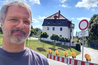 Umleitung um Langhennersdorf: Welche Sperrung es gleich neben der B 101 gibt - Reporter Wieland Josch am oberen Sperrschild in Langhennersdorf. Die Ortsdurchfahrt ist wegen Bauarbeiten nicht nutzbar.