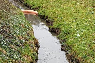 Unbekannte Substanz im Bach bei Penig bleibt ein Rätsel - Mit Ölsperren verhinderten die Einsatzkräfte in Langenleuba-Oberhain ein Ausbreiten der Substanz.